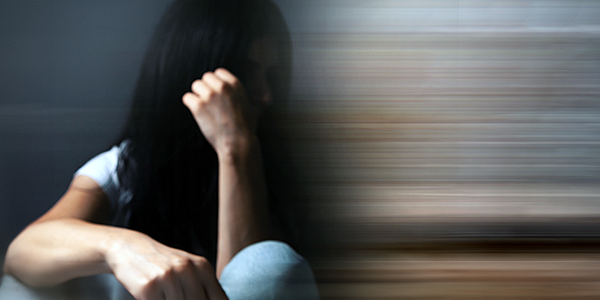 woman looking distressed and sitting on ground