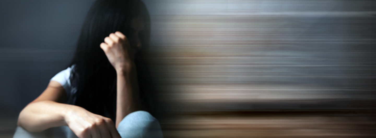 woman looking distressed and sitting on ground