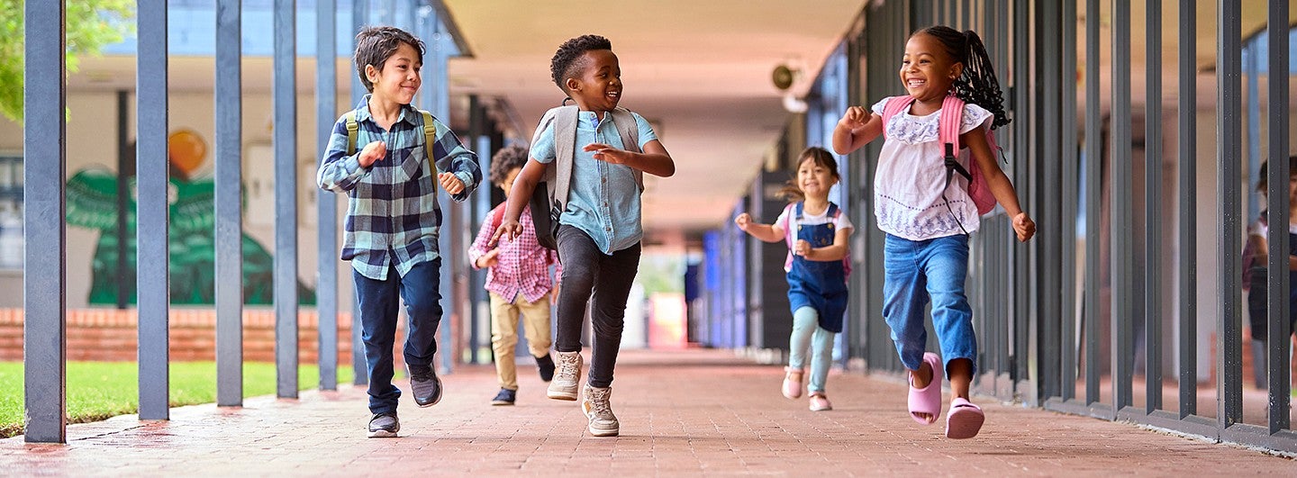happy school children skipping in the hall