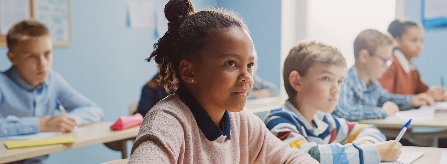 A girl working at a desk in an Elementary School Classroom