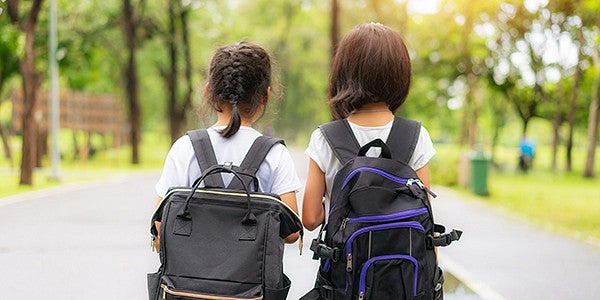 two school kids walking together 