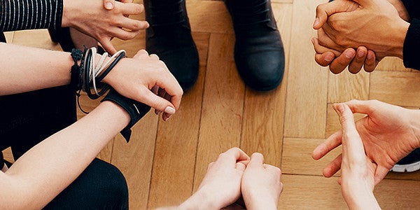 the hand and feets of teens sitting in a circle and talking