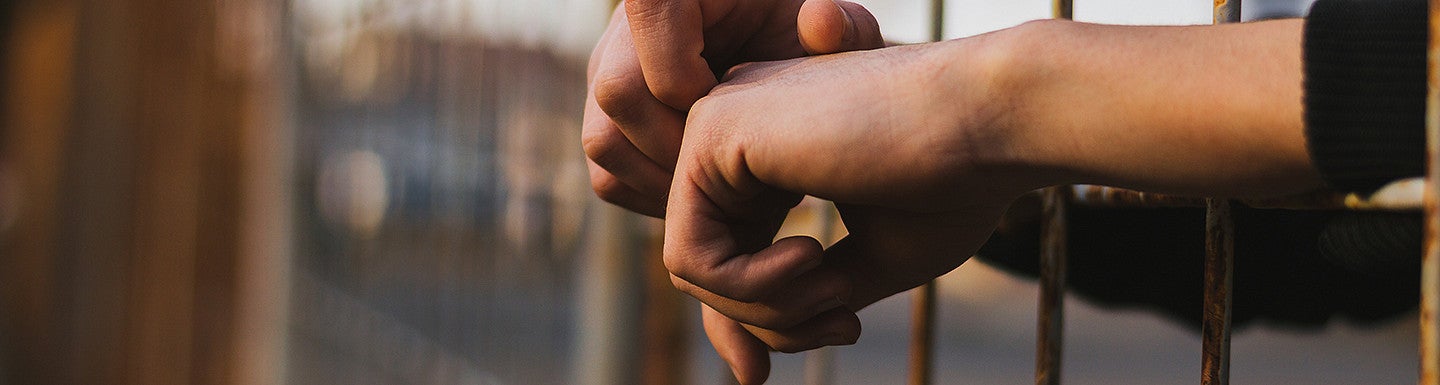 an inmate putting their hands outside the bars