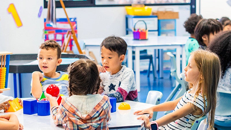 preschool teacher talking to children in school